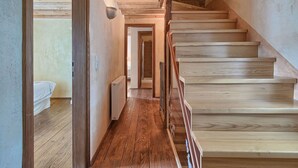 Una escalera de madera que lleva a un dormitorio con una cama y un radiador.