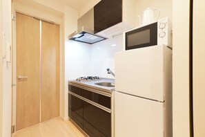 A compact kitchen with a refrigerator, microwave, and stove. - G-stage 01 IKEBUKURO 2 by Tranova (Toshima)
