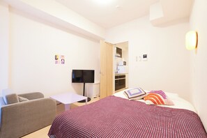 A hotel room with a bed, a sofa, a television, and a desk. - G-stage 01 IKEBUKURO 2 by Tranova (Toshima)