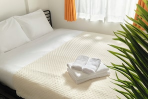 A neatly made bed with white linens and a folded towel on the bed. - Hotel Dieu Nakanobu by Tranova 2 (Shinagawa)