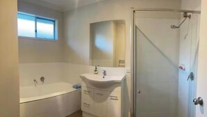 A bathroom with a bathtub, a sink, and a shower.