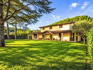 A two-story house with a covered patio, a lawn, and a tree in the foreground. - "Casa di Max" by Interhome (Arezzo)