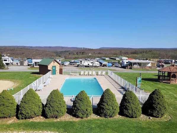 A campground with a swimming pool, RVs, and a gazebo. - James Creek RV Resort (James Creek)