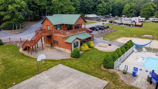 A large wooden cabin with a balcony, a basketball court, and a swimming pool. - James Creek RV Resort (James Creek)