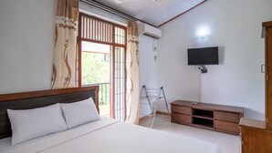 A bedroom with a bed, a TV mounted on the wall, a ceiling fan, and an air conditioning unit. - Kethmi Holiday Home (Pannipitiya)