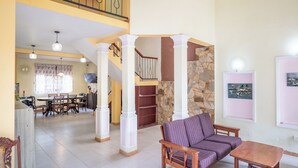 A spacious living area with a dining table, sofa, and staircase. - Kethmi Holiday Home (Pannipitiya)