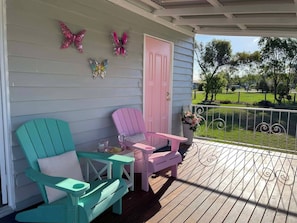 Une véranda avec deux chaises, une table et des décorations en forme de papillons.