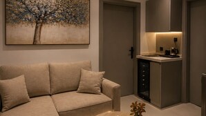 A modern living room with a sofa, coffee table, and a painting of a tree. - Comfortable Diamond Apartments Al Hamra (Jeddah)