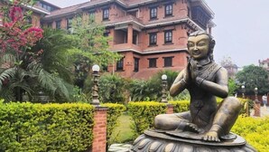 Eine Statue in einem Garten, im Hintergrund ein Gebäude mit der Aufschrift 'HOTEL YECHU'.