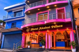 Um edifício com vários andares e uma placa visível com a inscrição 'Hotel Akshini Palace'.