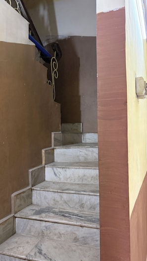 Un escalier avec des marches en marbre menant à un palier.