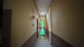 A narrow hallway with a skylight and a green-lit room at the end. - Hotel Akshni Palace (Purnia)