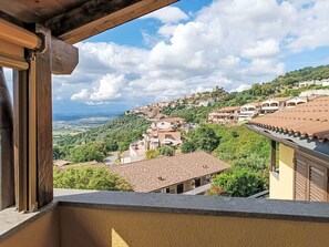 A view from a balcony overlooking a hillside town with terracotta-roofed buildings and lush greenery. - Bellavista by Interhome (Scarlino)
