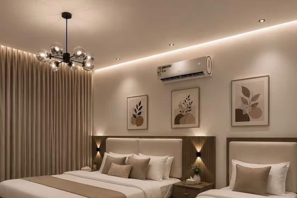 Un dormitorio moderno con dos camas, una araña, aire acondicionado y decoración mural.