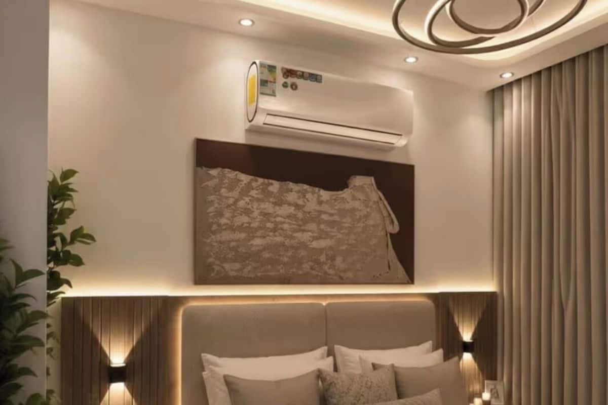 Un dormitorio moderno con una cama grande, aire acondicionado integrado, iluminación ambiental y un elemento decorativo en el techo.
