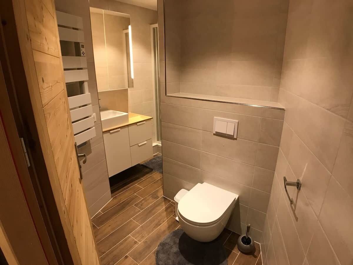 A bathroom with a toilet, a shower, and a sink.