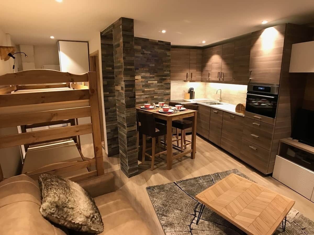 Eine moderne Küche mit Essbereich, Holzmöbeln und integrierten Geräten.
