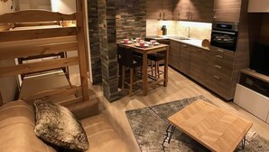 A modern kitchen with a dining area, wooden furniture, and built-in appliances. - Studio "Le Chamois" in Tignes Val Claret (Tignes)