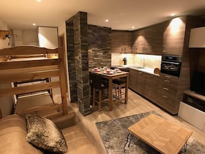 Eine moderne Küche mit Essbereich, Holzmöbeln und integrierten Geräten.