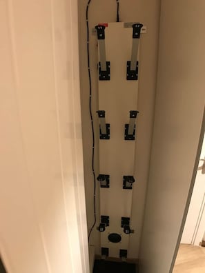 Ein schmaler Flur mit weißer Wand und einer Tür am Ende.