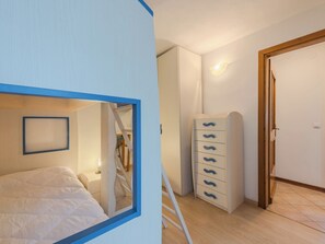 A bedroom with a bed, a wardrobe, a dresser, and a door. - Casa Roby by Interhome (Pinzolo)