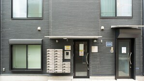 Un edificio moderno con una amplia puerta corrediza, un buzón y un letrero que indica que es un negocio.