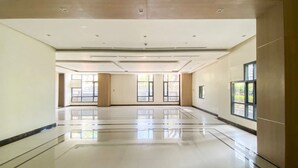 En rymlig och väl upplyst hotelllobby med ett polerat golv, stora fönster och en modern takdesign.