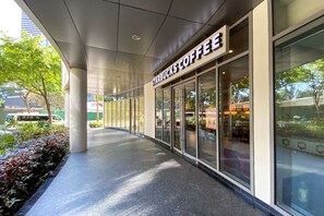 Ein Starbucks Coffee Geschäft mit überdachtem Zugang, großen Fenstern und Blick auf die Straße.