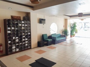 Eine Lobby mit Sitzgelegenheit, einem Wand-Fernseher, einem Feuerlöscher und einem gefliesten Boden.