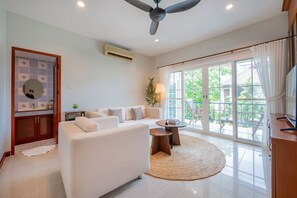 A modern living room with a sofa, a coffee table, and a TV.