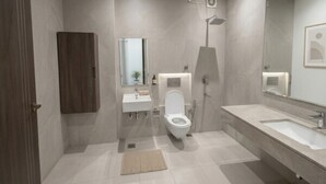 Moderni kylpyhuone, jossa on wc, pesuallas ja peili.