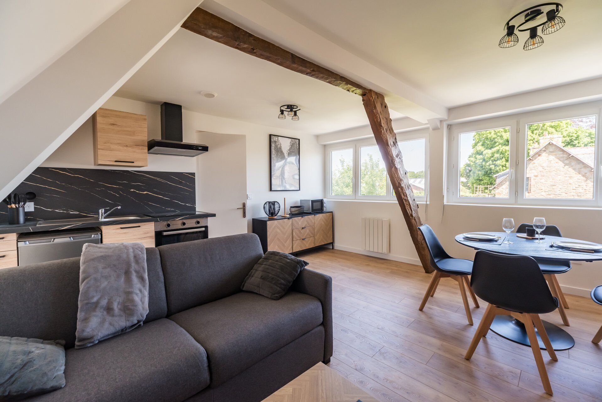 Un appartement moderne de style « loft », comprenant une cuisine, un coin repas et une grande fenêtre.
