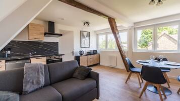 Un appartement moderne de style « loft », comprenant une cuisine, un coin repas et une grande fenêtre.
