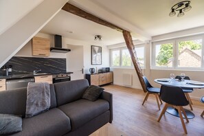 A modern loft apartment with a kitchen, dining area, and a large window. - Cozy loft in the heart of Guingamp (Guingamp)
