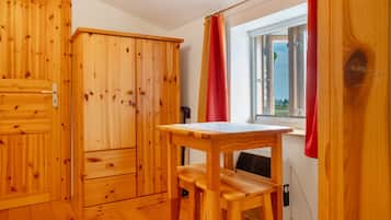 A wooden room with a window, a table, and a chair.