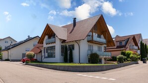 Een modern herenhuis met twee verdiepingen, een schuin dak, grote ramen en een duidelijke schoorsteen.