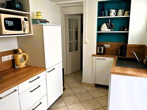 Eine Küche mit weißen Schränken, einer Mikrowelle, einem Toaster und einem Spülbecken.