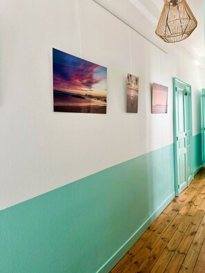 A hallway with a wooden floor, a teal-colored lower wall, and three framed pictures. - Ker Marin'o - 5 personnes (Les Sables-d´Olonne)