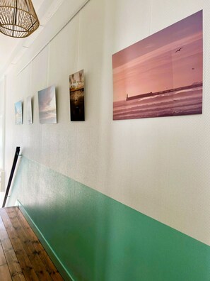 A hallway with a green and white wall, wooden flooring, and a hanging light fixture. - Ker Marin'o - 5 personnes (Les Sables-d´Olonne)