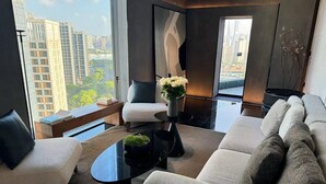A modern living room with a sofa, armchairs, a coffee table, and a view of high-rise buildings. - Atour S Hotel - Shanghai World Expo Lujiaizui Riverside Center  (Shanghai)