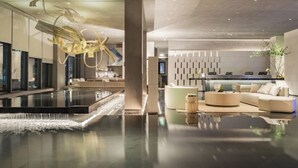 A modern lobby with a reflective floor, a central column, and a reception desk. - Atour S Hotel - Shanghai World Expo Lujiaizui Riverside Center  (Shanghai)
