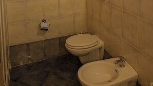 A bathroom with a toilet, bidet, and a sign instructing to keep windows closed. - Apartment 12 Maso Anna (Mastellina)
