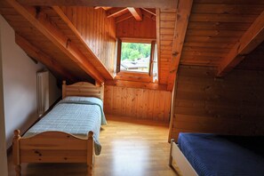 Una habitación pequeña de madera con dos camas y una ventana.