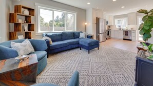 A modern living room with a sectional sofa, a wooden coffee table, and a patterned rug. - Rooftop Deck + Private Patio! West Seattle Home (Seattle)