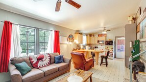 A living room with a sofa, coffee table, and a dining area with chairs and a table. - Next to Wine Rd! Apt w/ Balcony in Fredericksburg (Fredericksburg)