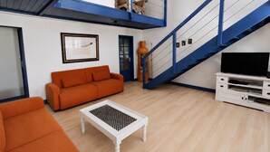 A living room with a sofa, coffee table, and TV stand.