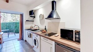 Una cocina compacta con lavadora, microondas y un lavabo.