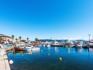 A marina with various boats docked, clear blue water, and buildings in the background. - Apartment Diana by Interhome (Ajaccio)