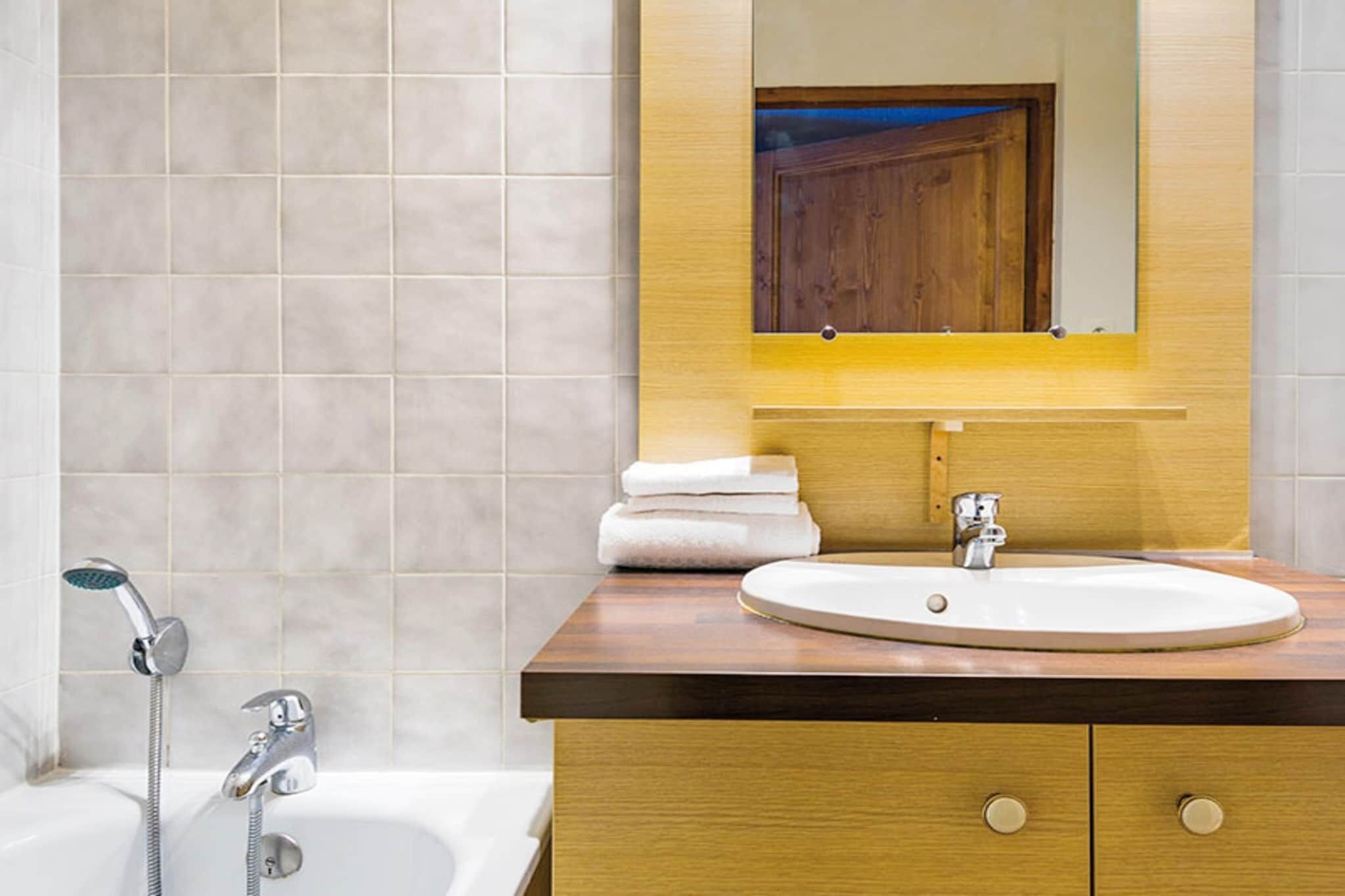 Une salle de bain avec un lavabo, un miroir et une douche.