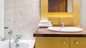 Un baño con lavamanos, espejo y ducha.